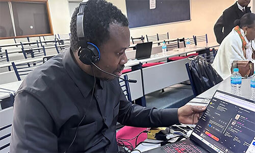 The Rev. Fiston Lutuku Okito, director of communications for the Central Congo Episcopal Area, uses a laptop and headphones to compose a song using an artificial intelligence platform. The hands-on activity took place as part of a course on artificial intelligence and digital information management offered as part of the new strategic communications program in Mutare, Zimbabwe. Photo by Chadrack Tambwe Londe, UM News.