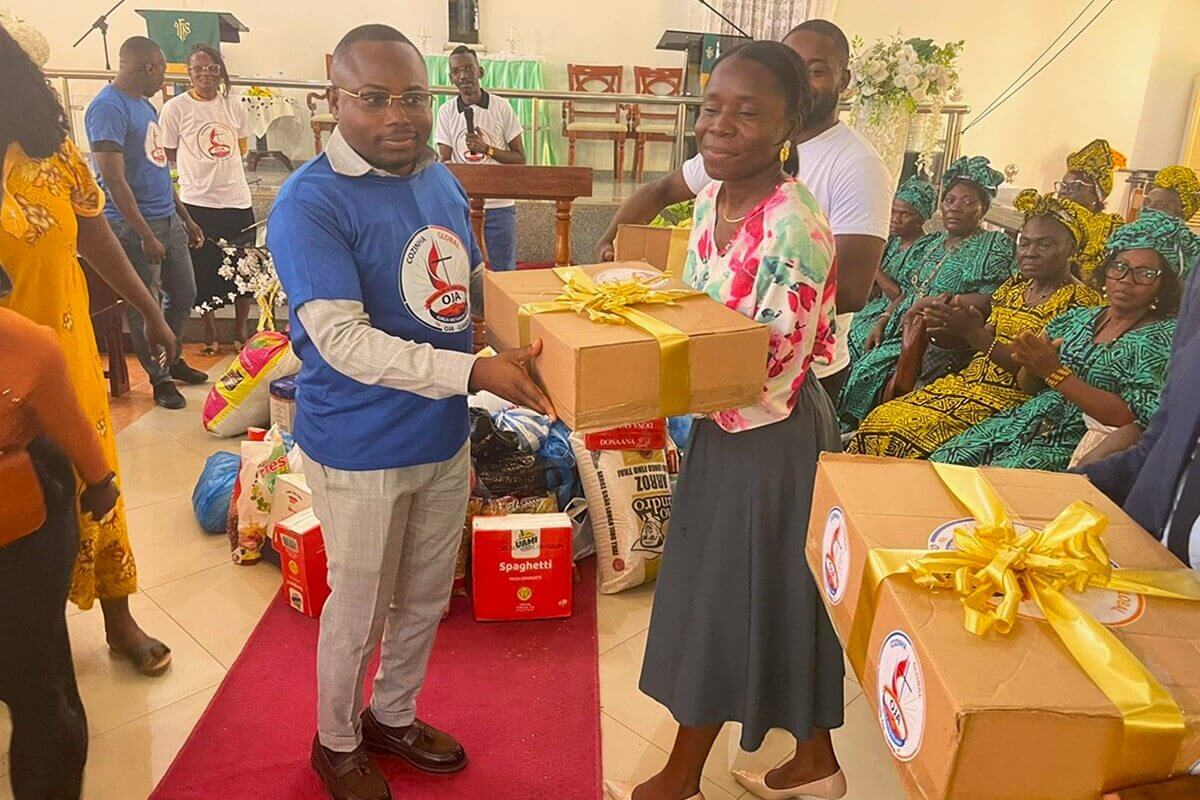 Mauro de Oliveira, coordenador do projecto e director distrital dos Jovens Adultos do Distrito de Luanda fazendo a entrega simbólica de kits da cesta básica à coordenadora da Intendência para fazer chegar aos mais desfavorecidos.